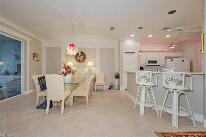 Dining space featuring ceiling fan, light tile patterned flooring, and ornamental molding