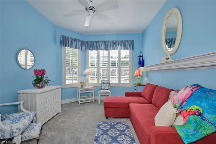 Living room with light colored carpet and ceiling fan