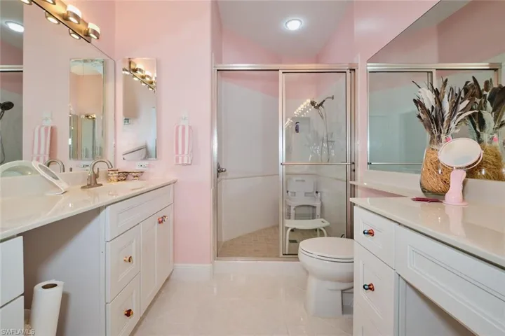 Bathroom with tile patterned flooring, toilet, a shower with door, and vanity