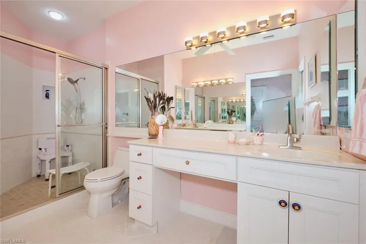 Bathroom featuring tile patterned floors, toilet, vanity, and a shower with shower door