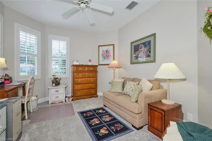 Living area featuring ceiling fan and carpet flooring