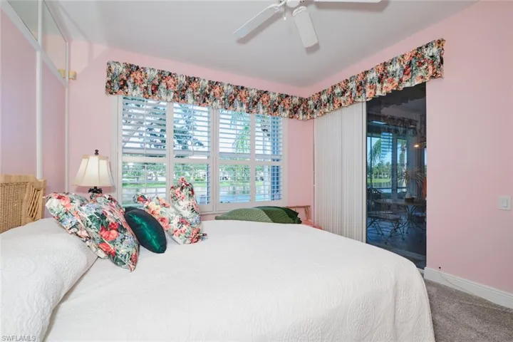 Carpeted bedroom featuring ceiling fan and access to exterior
