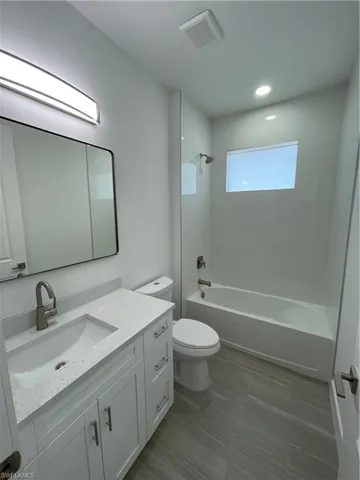 Bathroom with vanity, shower / tub combination, and recessed lighting