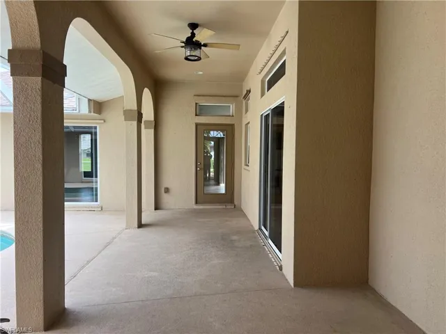 Covered lanai leads from double entry doors to main front door entry into home. Notice the front door, sliders, and window over kitchen sink all have glass transoms adding extra natural light into home.