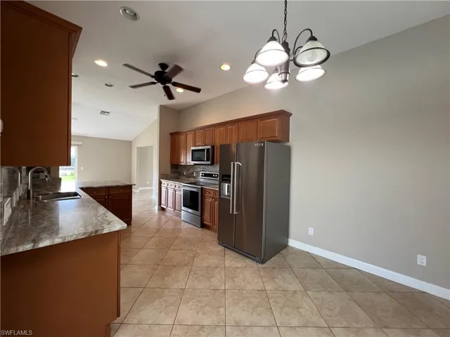 Open floor plan with kitchen opening onto pool and living dining area.