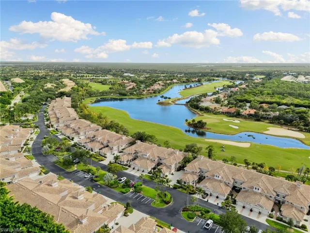 Aerial view of residential area with a golf course and a nearby body of water