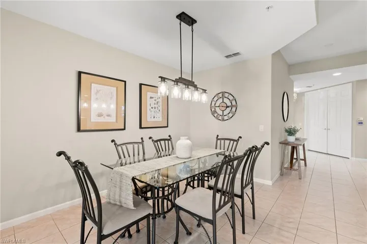 Dining area with light tile patterned floors and recessed lighting