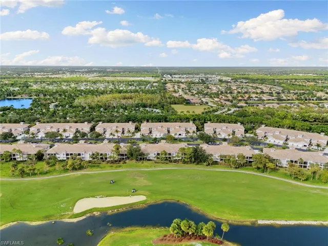 Aerial view of residential area featuring a nearby body of water and a local golf course