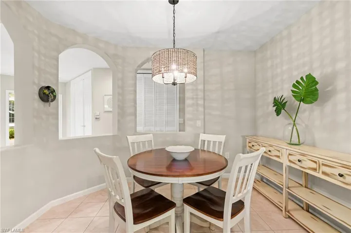 Tiled dining room featuring a chandelier and baseboards