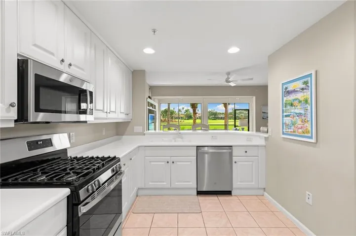 Kitchen featuring stainless steel appliances, white cabinets, light countertops, light tile patterned floors, and recessed lighting