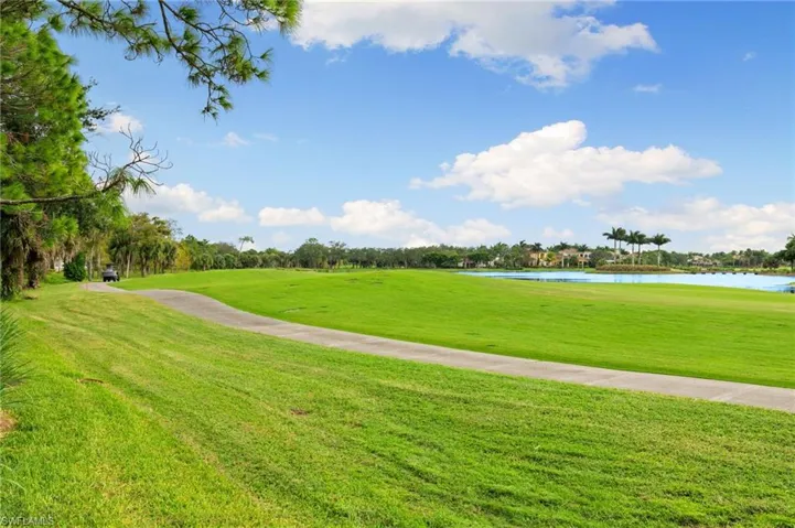 View of property's community featuring a yard, a water view, and golf course view
