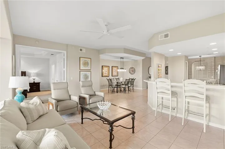 Living area featuring light tile patterned floors, a chandelier, a ceiling fan, and recessed lighting