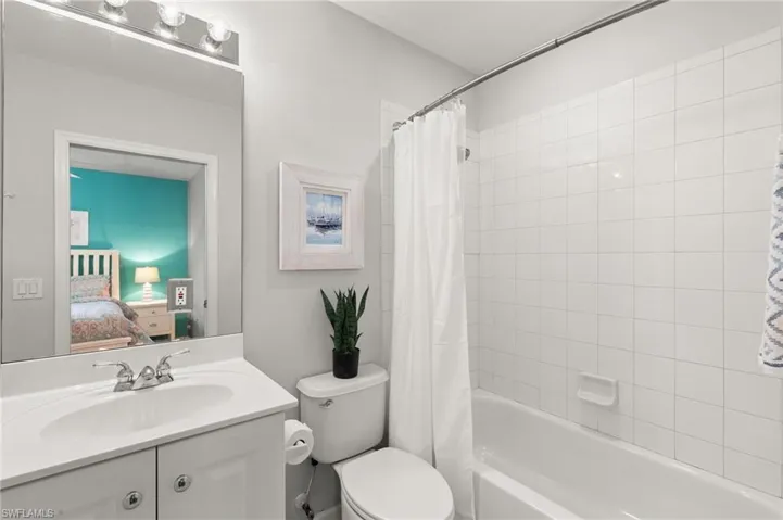 Ensuite bathroom featuring vanity and shower / bathtub combination with curtain