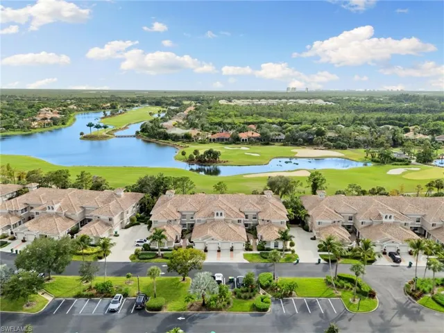 Aerial perspective of suburban area featuring a golf course and a large body of water