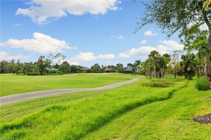 Surrounding community featuring view of golf course, a lawn, and a residential view