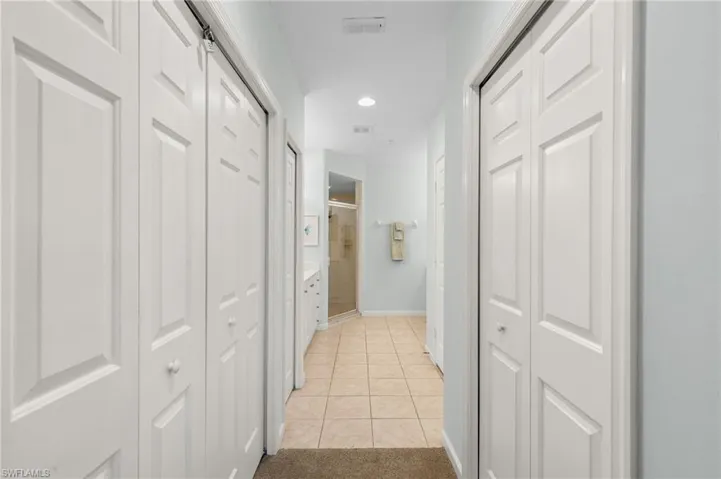 Corridor with light tile patterned floors and recessed lighting