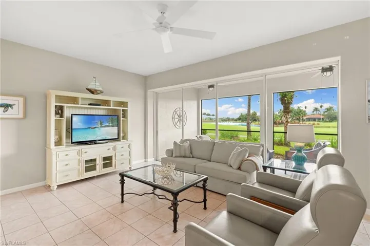 Living room featuring light tile patterned floors and a ceiling fan