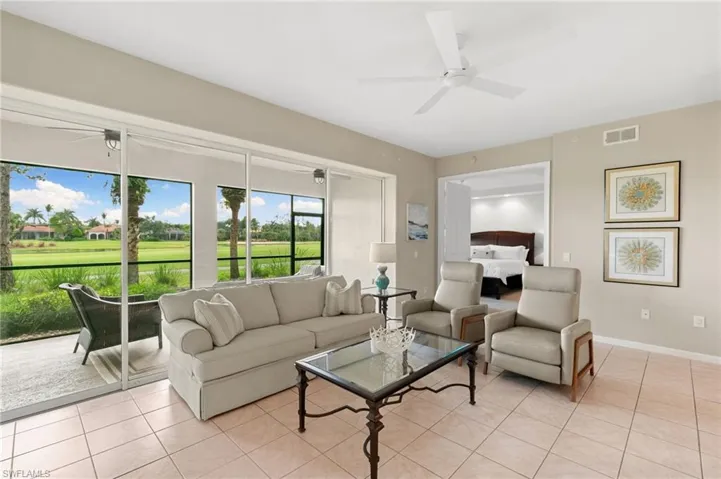 Living area with a ceiling fan, golf course view, and light tile patterned floors