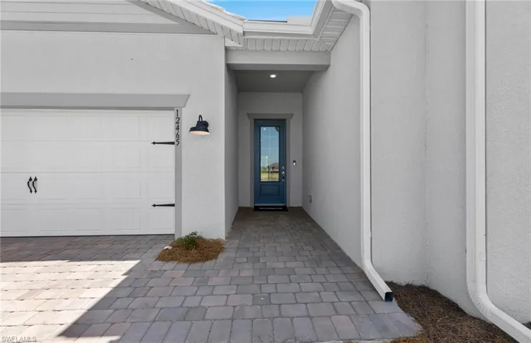 View of exterior entry with a garage