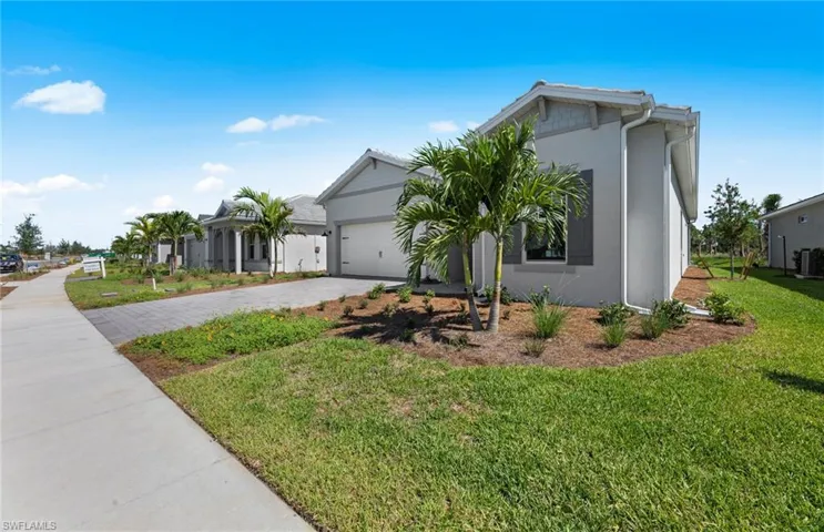 View of front facade with a front yard, a garage, and central air condition unit