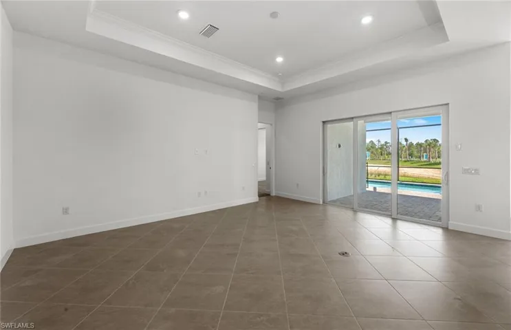Tiled spare room featuring a raised ceiling
