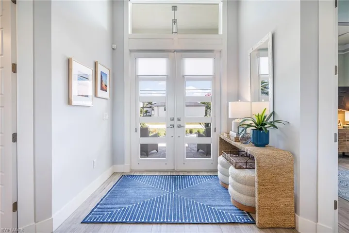 Entryway with baseboards, wood look tile floors, and french doors