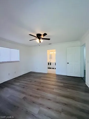 Unfurnished bedroom featuring a ceiling fan, dark wood-style floors, and crown molding