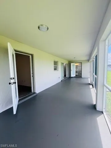 Unfurnished sunroom featuring concrete flooring and a textured wall