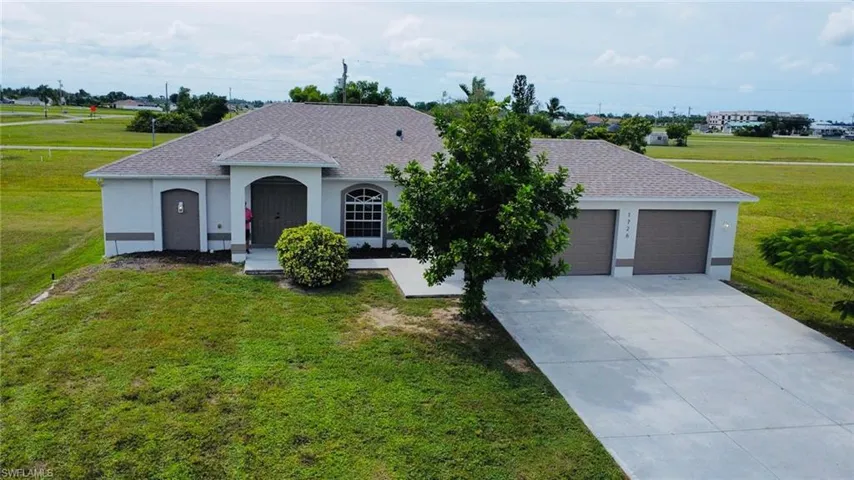 View of front of home featuring a front lawn, stucco siding, an attached garage, and concrete driveway