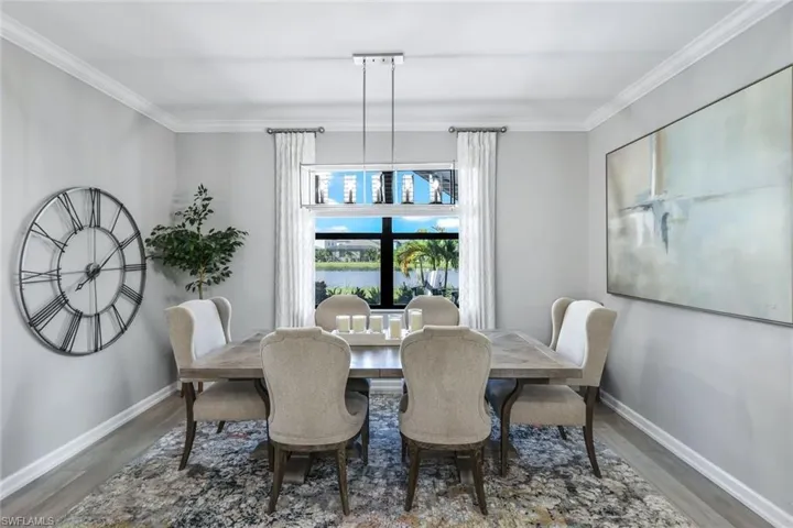 Dining space featuring wood-type flooring and crown molding