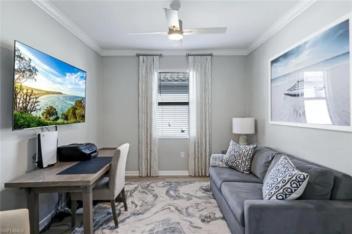 Office space with ceiling fan, crown molding, and light hardwood / wood-style floors