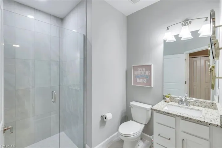 Bathroom with walk in shower, vanity, and toilet