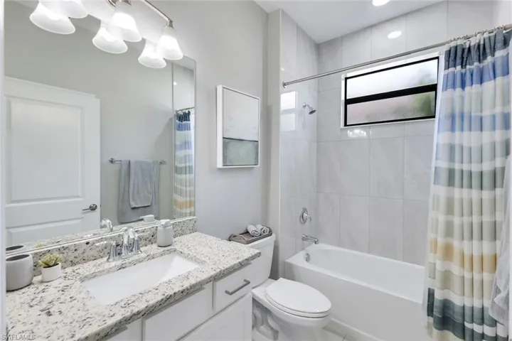Full bathroom with shower / tub combo with curtain, vanity, and toilet