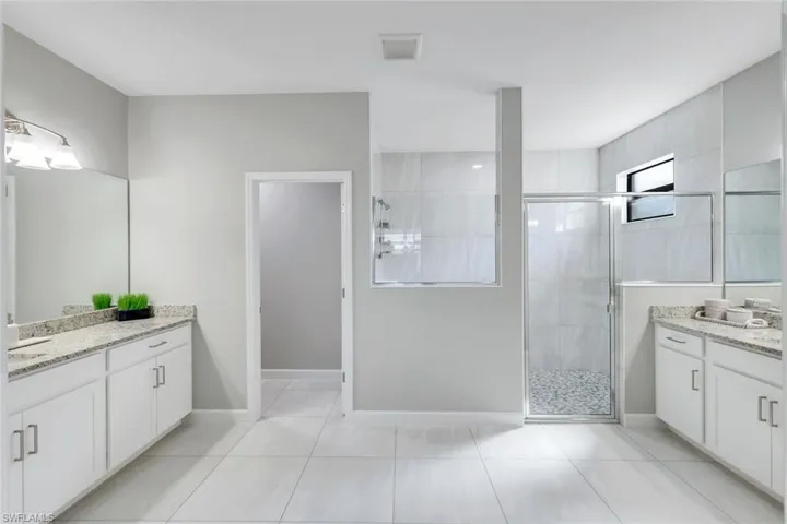 Bathroom featuring vanity, a shower with shower door, and tile patterned floors