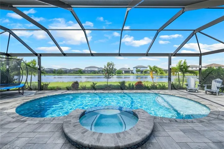 View of swimming pool featuring a lanai, a patio, and a water view