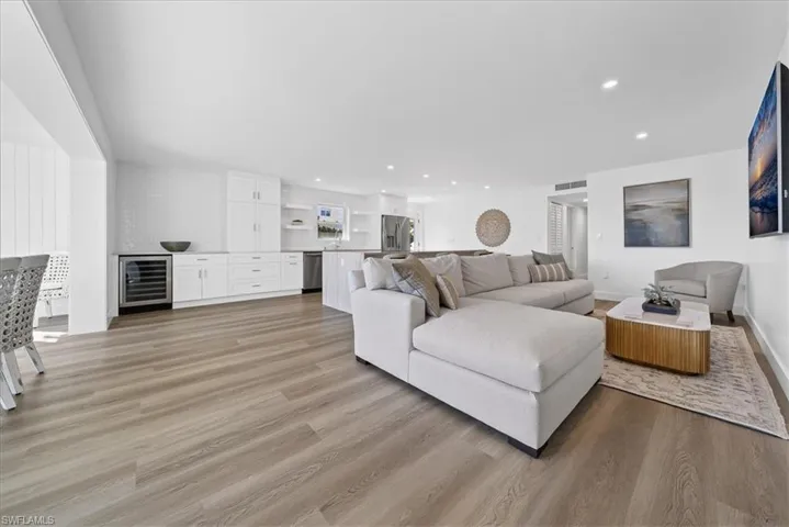 Living room with light wood finished floors, wine cooler, and recessed lighting