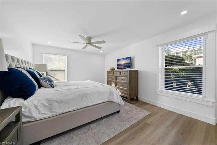 Bedroom with wood finished floors, a ceiling fan, and recessed lighting