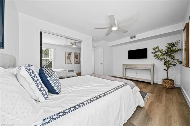 Bedroom featuring dark wood-style flooring, a closet, and a ceiling fan