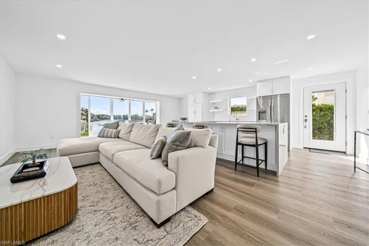 Living room featuring light wood-style flooring, plenty of natural light, and recessed lighting