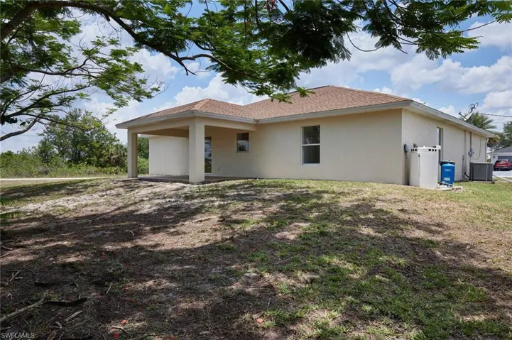 View of side of property featuring stucco siding and central AC unit