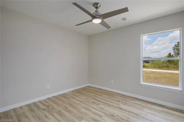 Empty room with light wood-type flooring, baseboards, and ceiling fan