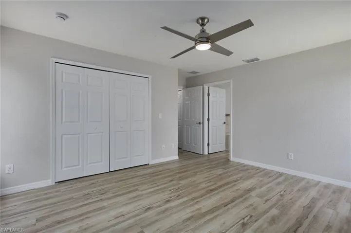 Unfurnished bedroom with light wood-type flooring, baseboards, a closet, and ceiling fan