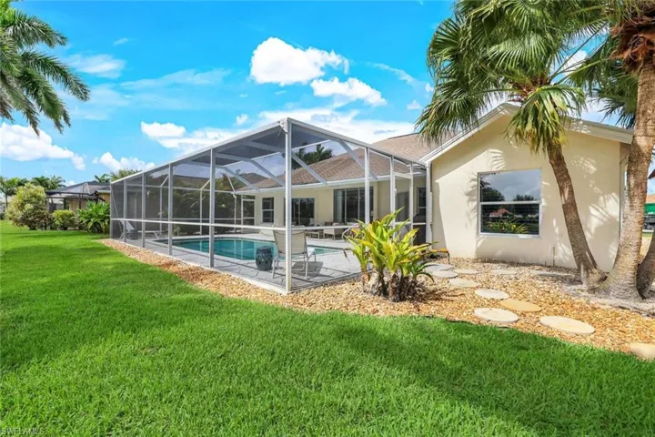 Back of house featuring a lawn, a lanai, and a patio