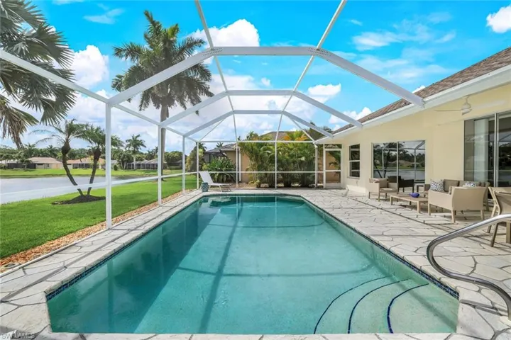 View of swimming pool featuring a patio, a lanai, and a lawn