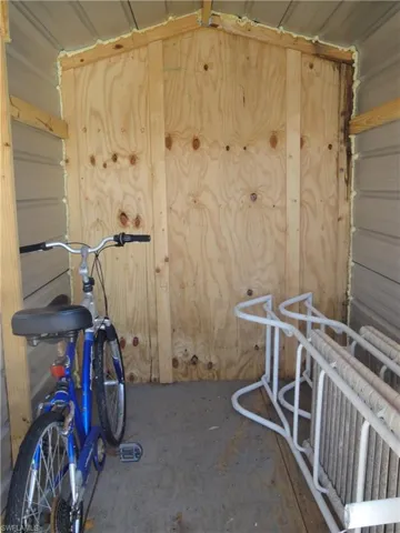 Aluminum shed which is strapped to the concrete.