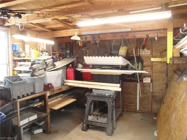 Interior of the second garage. Large storage area with shelving, workbench and vise.