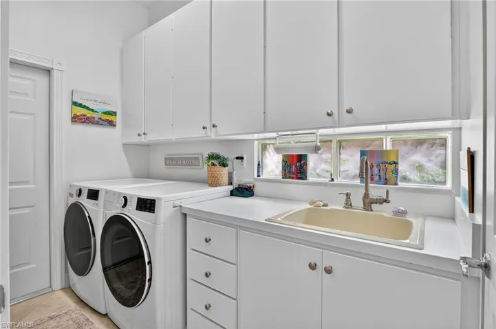 Laundry area with sink, washing machine, dryer and cabinet space