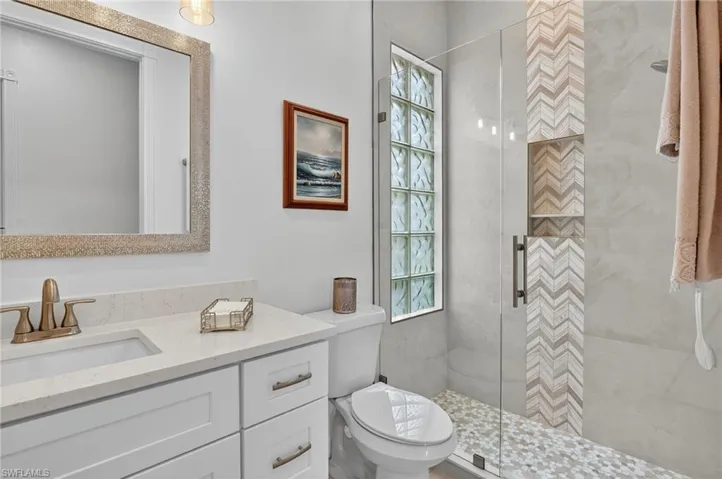 Full bath featuring a stall shower and vanity