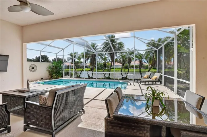 Swimming pool with a patio, a sunroom, a ceiling fan, and glass enclosure