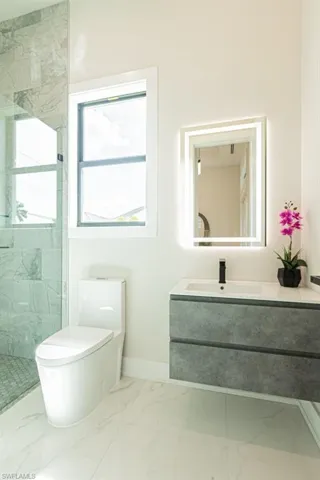 Bathroom with vanity, toilet, and a tile shower